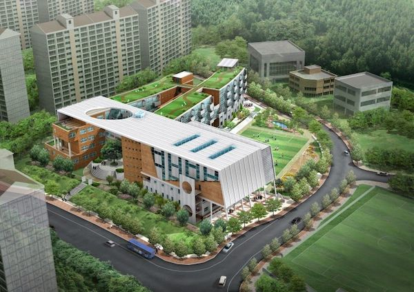 A building with a parking lot and trees Description automatically generated with medium confidence